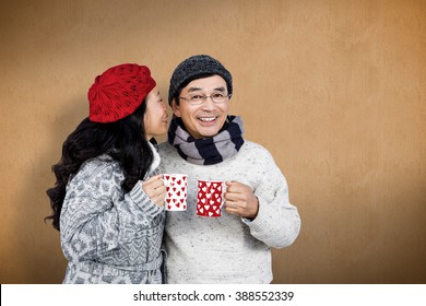 Older Asian Couple Having Hot Drinks Against Orange Background