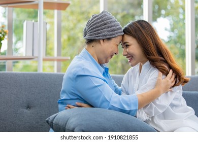 Older Asian Woman Patient Covered The Head With Clothes Effect From Chemo Treatment In Cancer Cure Process Touch Her Daughter's Forehead With Happy.