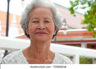 Older Asian Women With Grayish Hair Have Smiling Faces OnTemple Background