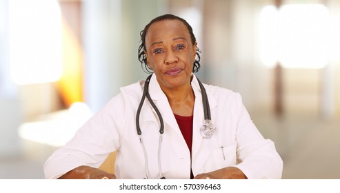 An Older Black Doctor Looking At Camera With Concern