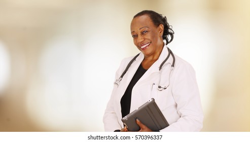 An Older Black Doctor Posing For A Portrait In Her Office