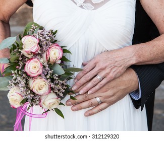 Older Bride And Groom Hands And Rings With Flowers