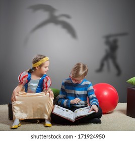 Older Brother Reading A Fairy Tale About A Knight And A Dragon To His Little Sister 