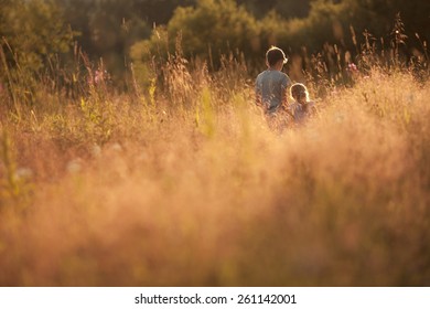 Older Brother And Sister Are In A Summer Field At Sunset