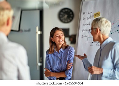 An Older Business Woman Asks Young Female Colleague A Question During A Presentation In A Pleasant Atmosphere At Workplace. Business, Office, Job