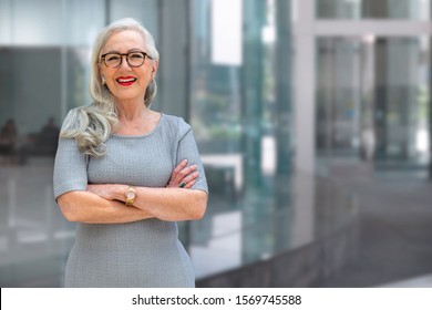 Older Business Woman CEO Standing And Smiling Confident, Successful, At Office Building With Copy Space