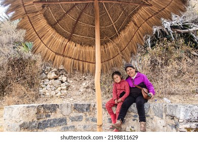 Older Caucasian Woman, Hiking In The Mountains With Her Latina Granddaughter.