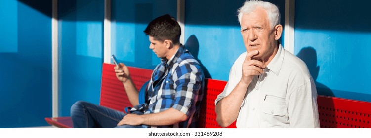 Older confused man and young boy on a bus stop
