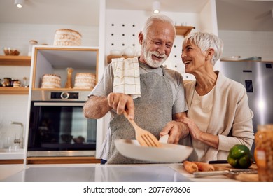 An older couple cooking a healthy vegan meal with vegetables together - Powered by Shutterstock