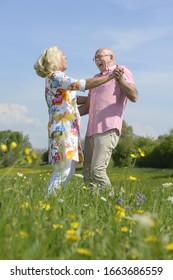 Older Couple Dancing Together In Meadow