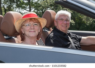 Older Couple Drives With A Luxury Convertible Car