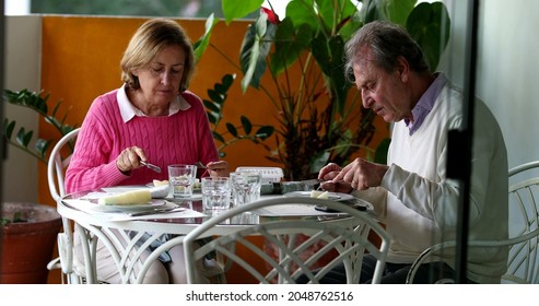 Older Couple Eating Lunch Together, Candid Authentic Real Life Senior Couple At Home Balcony