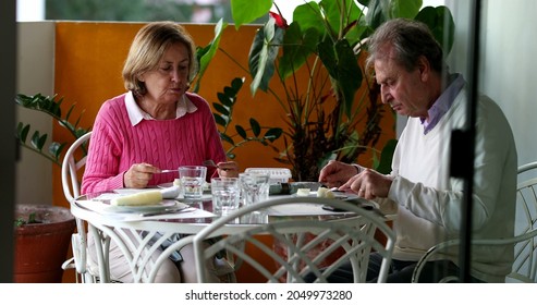 Older Couple Eating Lunch Together, Candid Authentic Real Life Senior Couple At Home Balcony