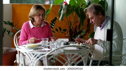 Older Couple Eating Lunch Together, Candid Authentic Real Life Senior Couple At Home Balcony