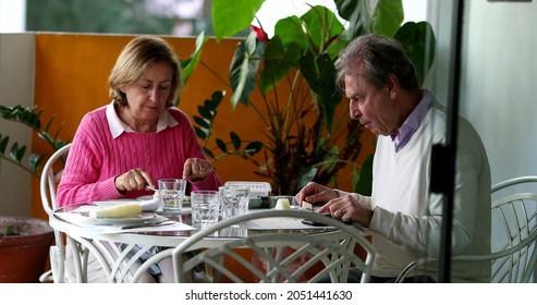 Older Couple Eating Lunch Together, Candid Authentic Real Life Senior Couple At Home Balcony