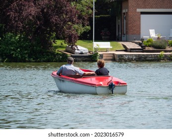 Older Couple Enjoy A Boat Trip On A Lake With An Electric Boat