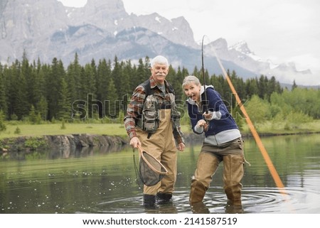 Older couple fishing in still lake