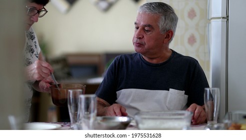 Older Couple At Home Eating Lunch, Wife Serving Food To Husband, Authentic And Candid