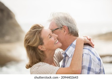 Older Couple Kissing On Beach