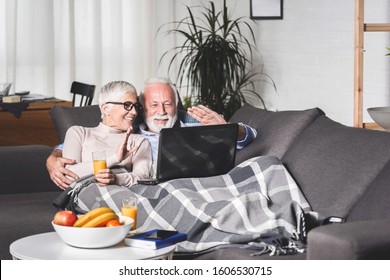 Older Couple Is Lying On The Couch And Talking On The Internet On A Tablet With Their Children