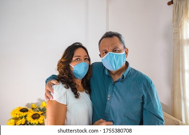 Older Couple With Medical Mask In Their Living Room