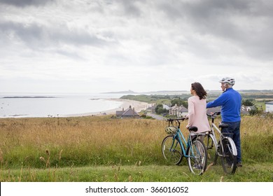 An Older Couple Are Out On A Bike Ride, They Have Stopped To Enjoy The View.