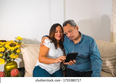 Older Couple Reading On The Couch At Home