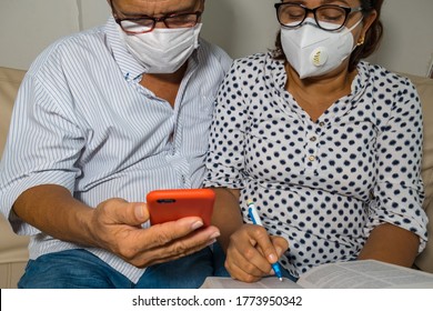 Older Couple With A Relaxed Medical Mask Reading A Message On Their Mobile Phone