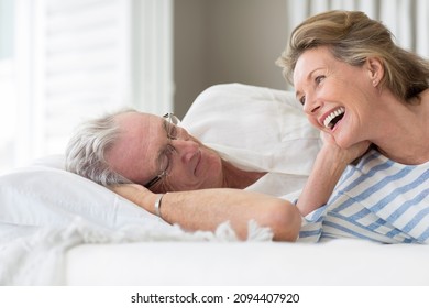 Older Couple Relaxing On Bed