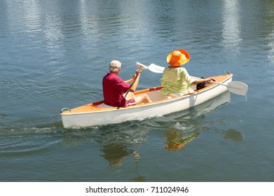 Older Couple Rowing Canoe On Lake