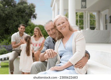 Older couple smiling on porch - Powered by Shutterstock