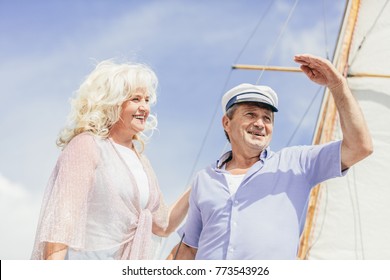 Older Couple Standing On A Yacht, Looking Away. Summertime Tourists Adventure.