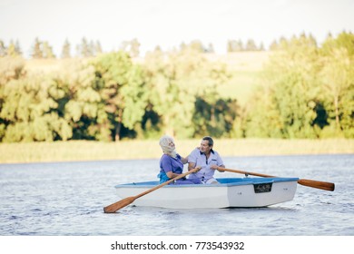 Older Couple Swimming On A Lake. Romantic Sailing On A Boat. Love Concept.