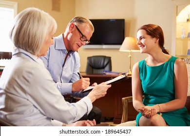 Older Couple Talking To Financial Advisor In Office