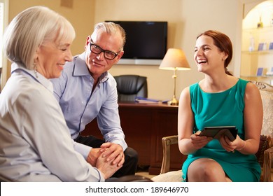 Older Couple Talking To Financial Advisor In Office