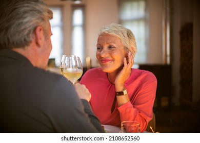 Older Couple Toasting Each Other With White Wine