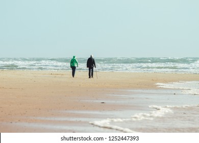 Older Couple Walking At The Beach.