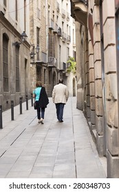 An Older Couple Walking In The Narrow Streets.