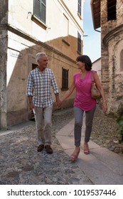 Older Couple Walking On Cobbled Street