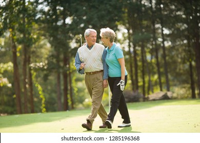 Older Couple Walking On Golf Course