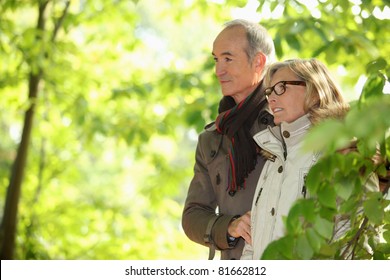 Older Couple Walking In The Woods