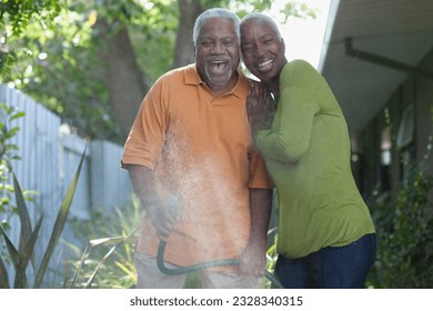 Older couple watering plants in backyard - Powered by Shutterstock