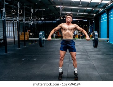 Older Defined Muscular Man Olympic Lifting In Gym