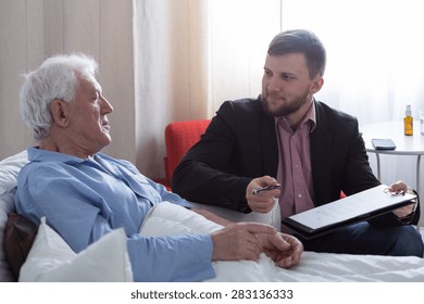Older dying man in hospital talking with his notary