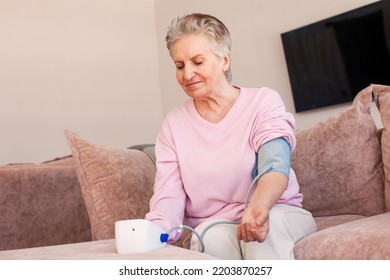 Older Elder Woman Measuring Blood Pressure, Using Digital Tonometer Machine At Home. Healthcare, Disease Treatment Concept.