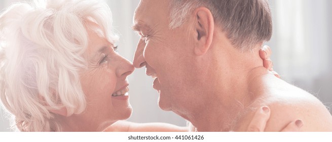 Older And Enamored Couple Is Preparing For A Passionate Kiss