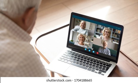 Older Generation And Modern Technologies For Virtual Visual Communication Concept. Old Man Makes Videocall Talking With Relatives Or Friends By Video Conference App, Pc Screen View Over Male Shoulder