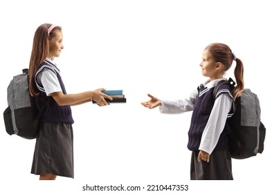 Older Girl Giving Books To A Younger Schoolgirl Isolated On White Background