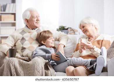 Older grandparents reading a book to their young grandson