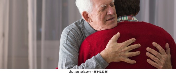 Older Grateful Man Hugging His Helpful Caregiver